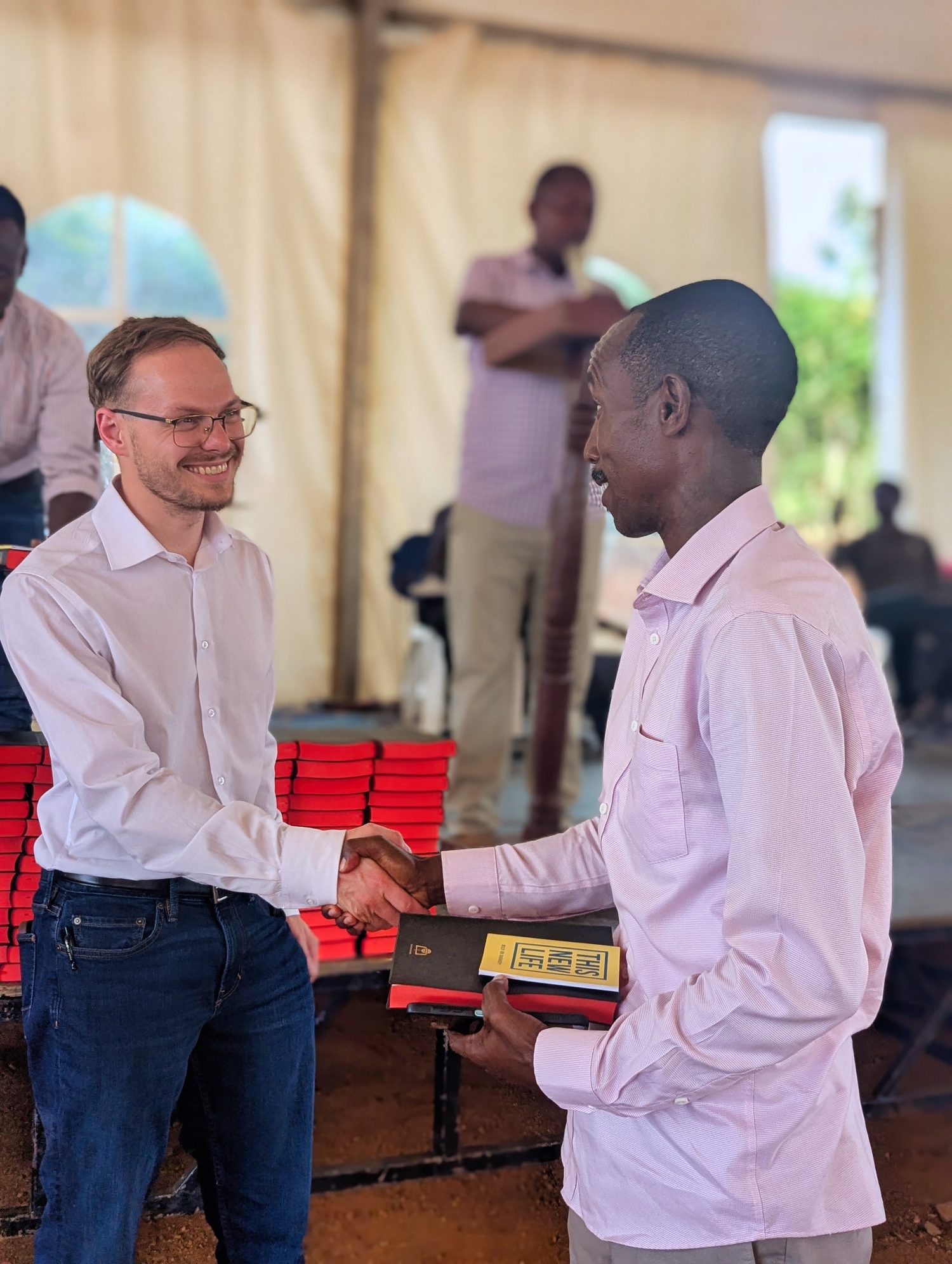 One believer greeting another at the front of the tent, person to person.